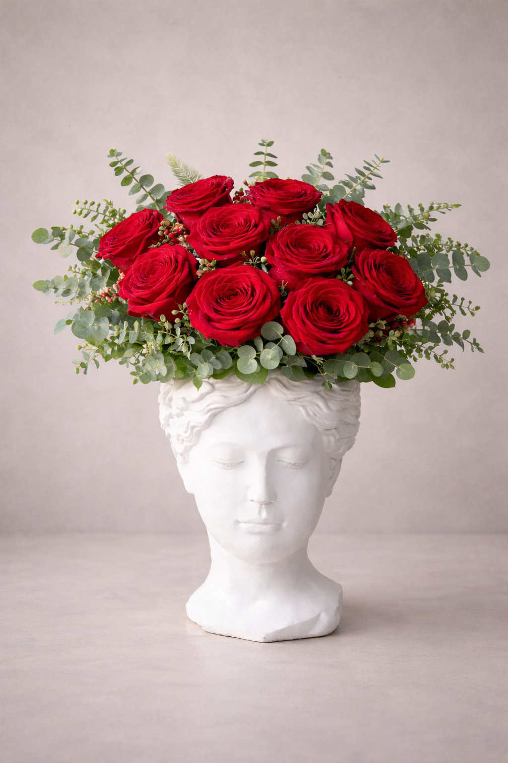 Bouquet of red roses in a white classical vase on a light gray background