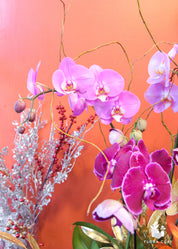 purple pink orchid arrangement in a wooden pot