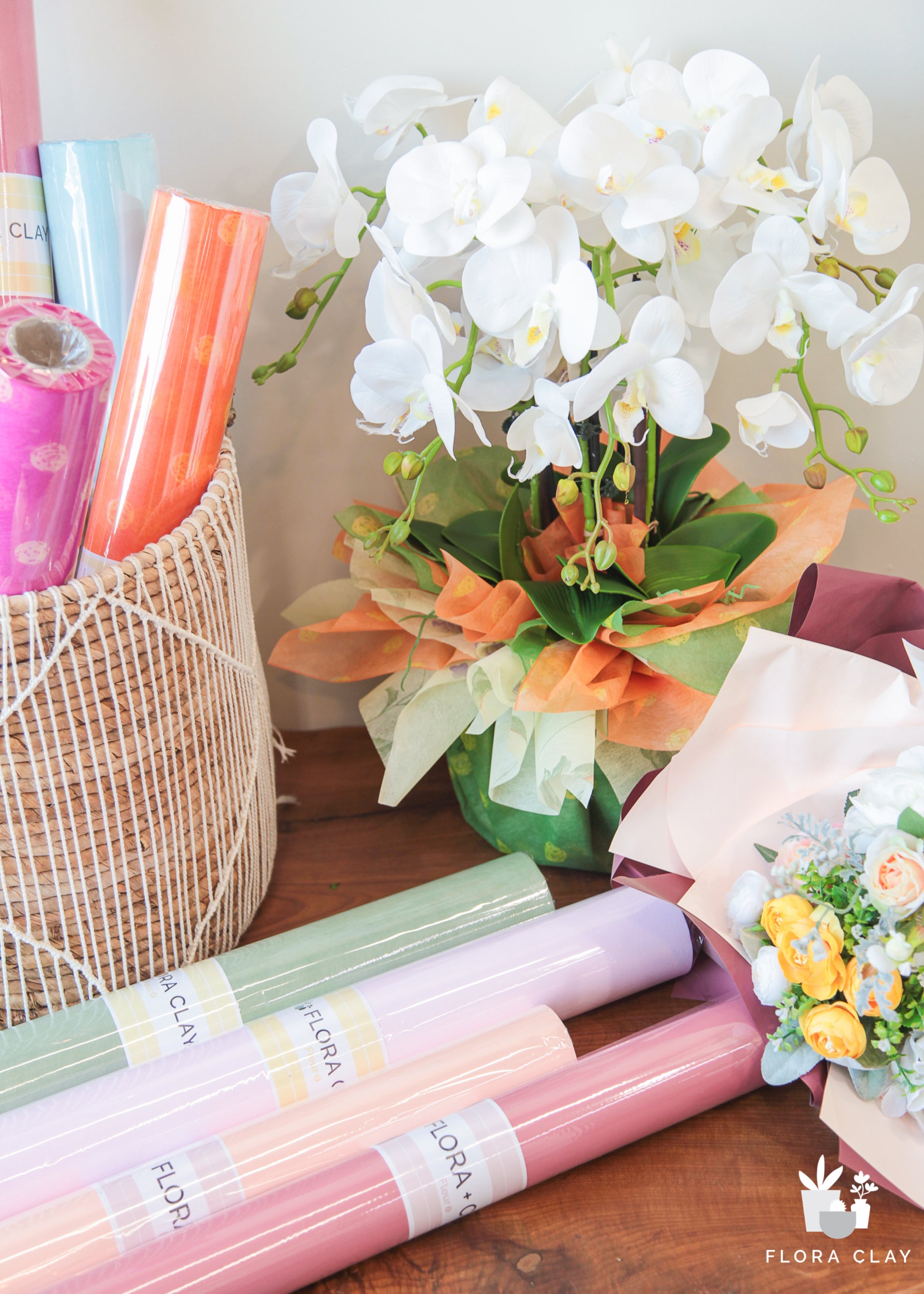 Assorted colorful flower wrapping papers displayed with a vase of flowers, indicating various colors available for gift wrapping.